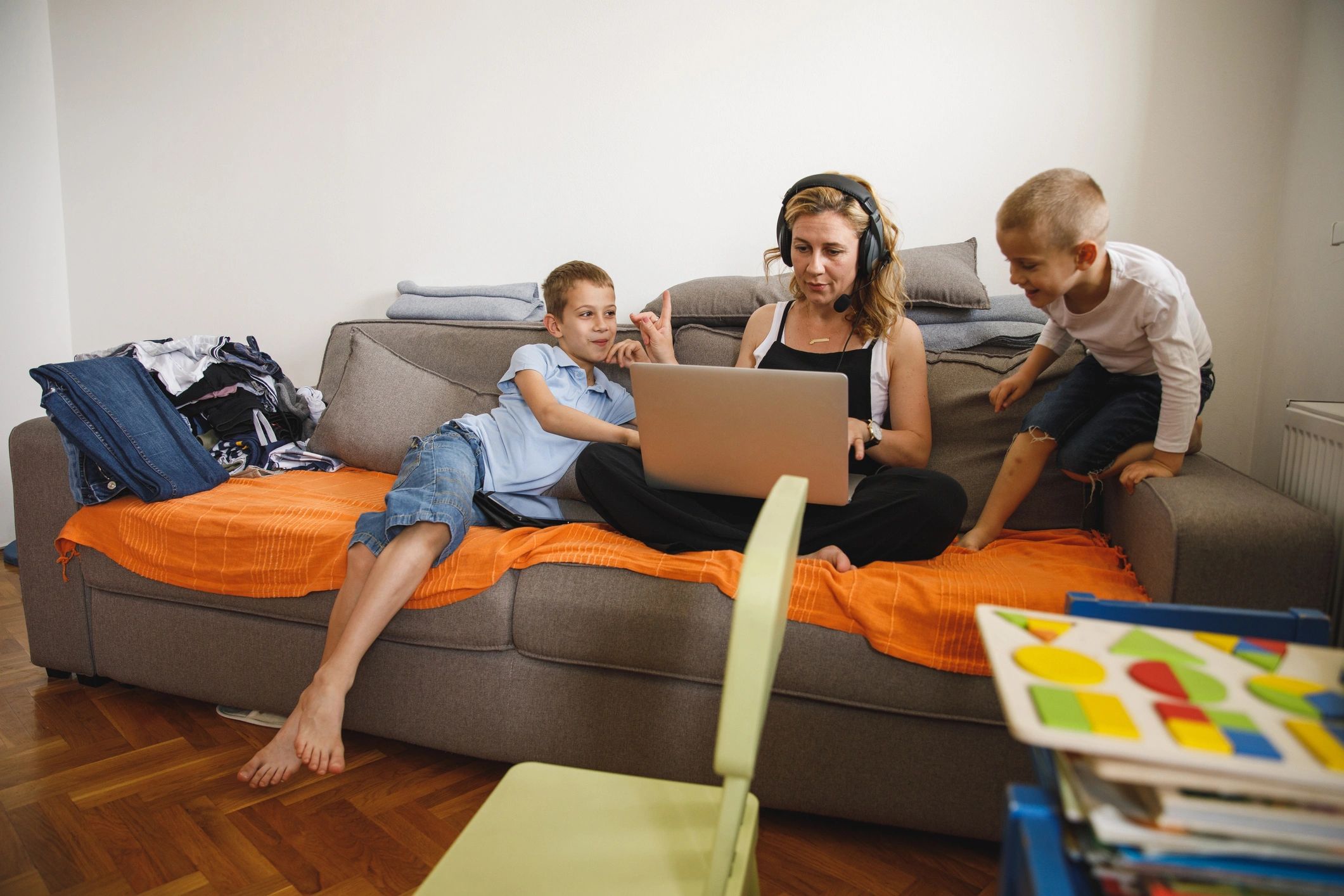 Mother working from home with two sons nearby