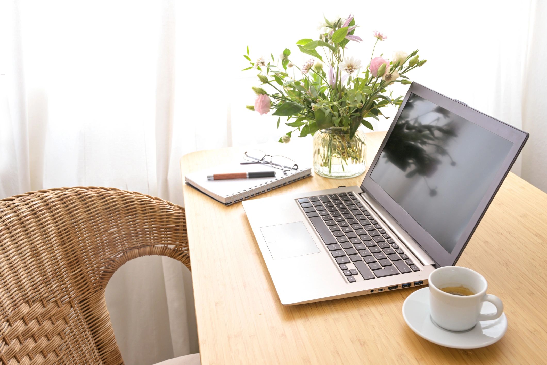 Feminine home workspace with laptop, flowers, and coffee
