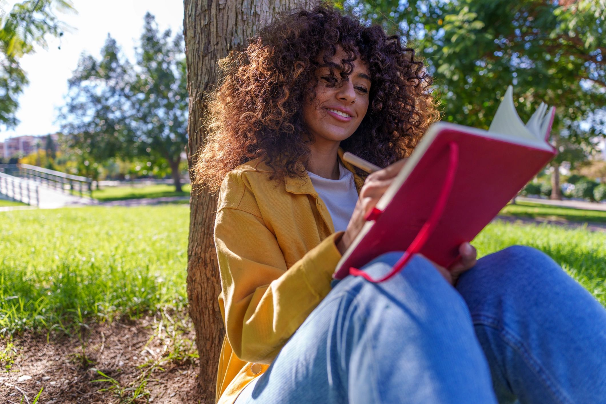 Woman journaling outdoors with coffee nearby